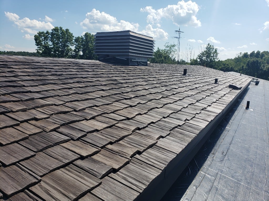 Commercial building with sloped shingle roof and flat membrane section